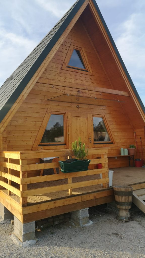 Casa A-Frame em madeira maciça de pinho nórdico construída pela MF, com alpendre em deck e cobertura verde