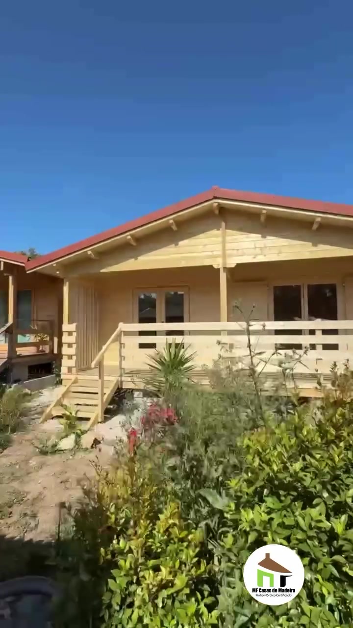 Casa de madeira térrea com varanda corrida e jardim em flor, obra MF concluída