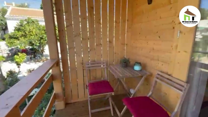 Recanto do alpendre com resguardo em ripado de madeira e mesa de esplanada
