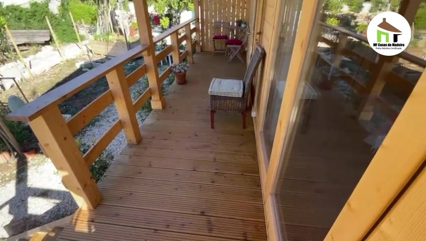 Deck lateral em madeira com guarda, ao longo da fachada da casa