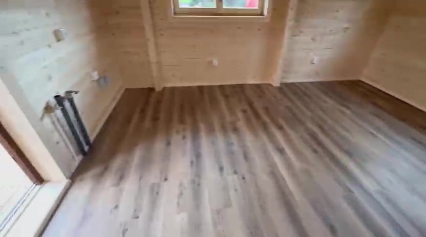 Divisão ampla com pavimento laminado e paredes em madeira maciça