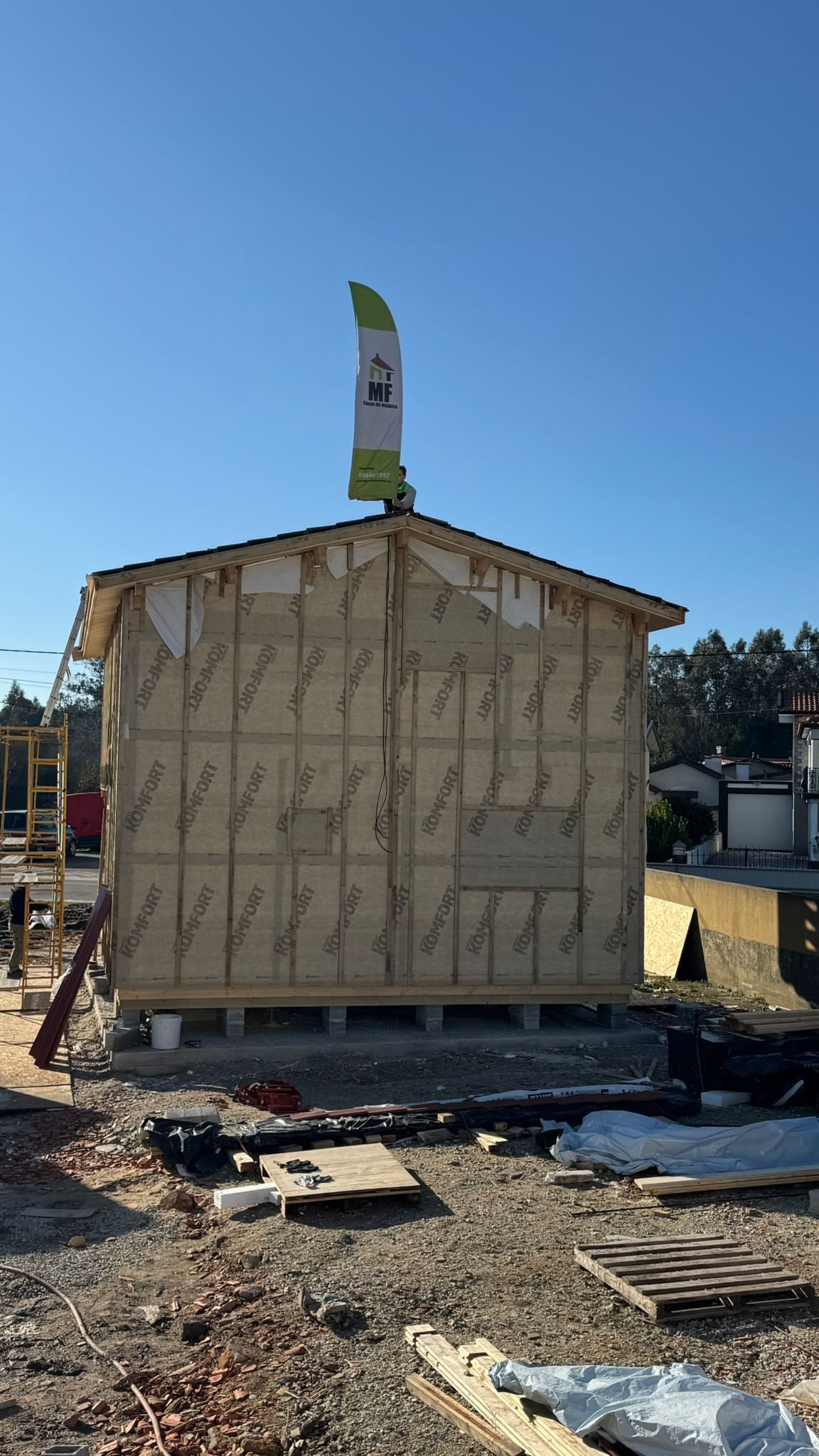 Membrana exterior respirável e ripado vertical na fachada traseira da casa de madeira