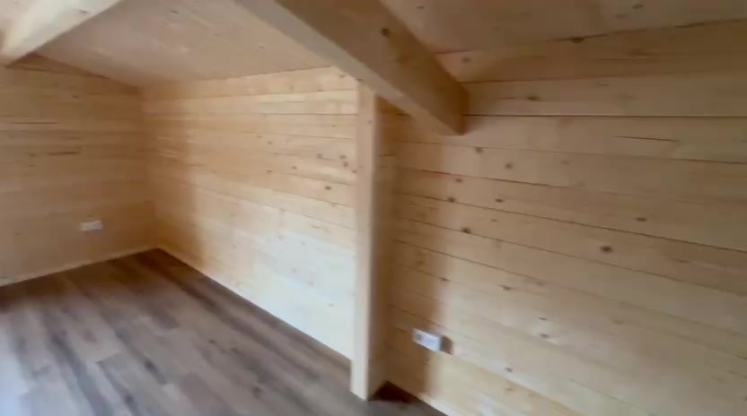 Quarto do primeiro piso com teto inclinado em madeira