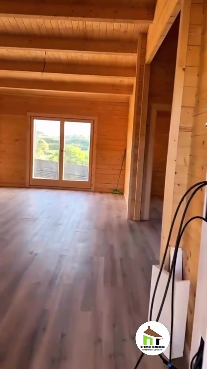 Divisão ampla com porta-janela e pavimento laminado escuro