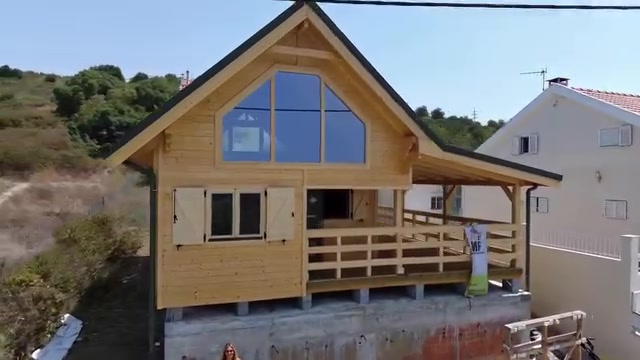 Casa de madeira modelo Estrela T2 de 90 m² com grande empena envidraçada e alpendre, obra MF