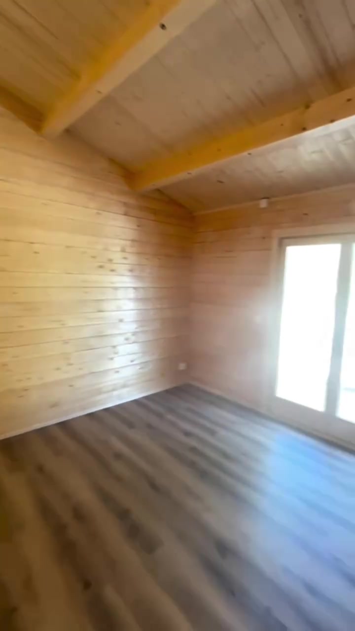 Quarto com porta-janela para o deck e paredes em pinho nórdico maciço