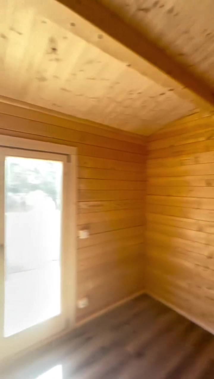 Quarto com teto inclinado em pinho e porta-janela