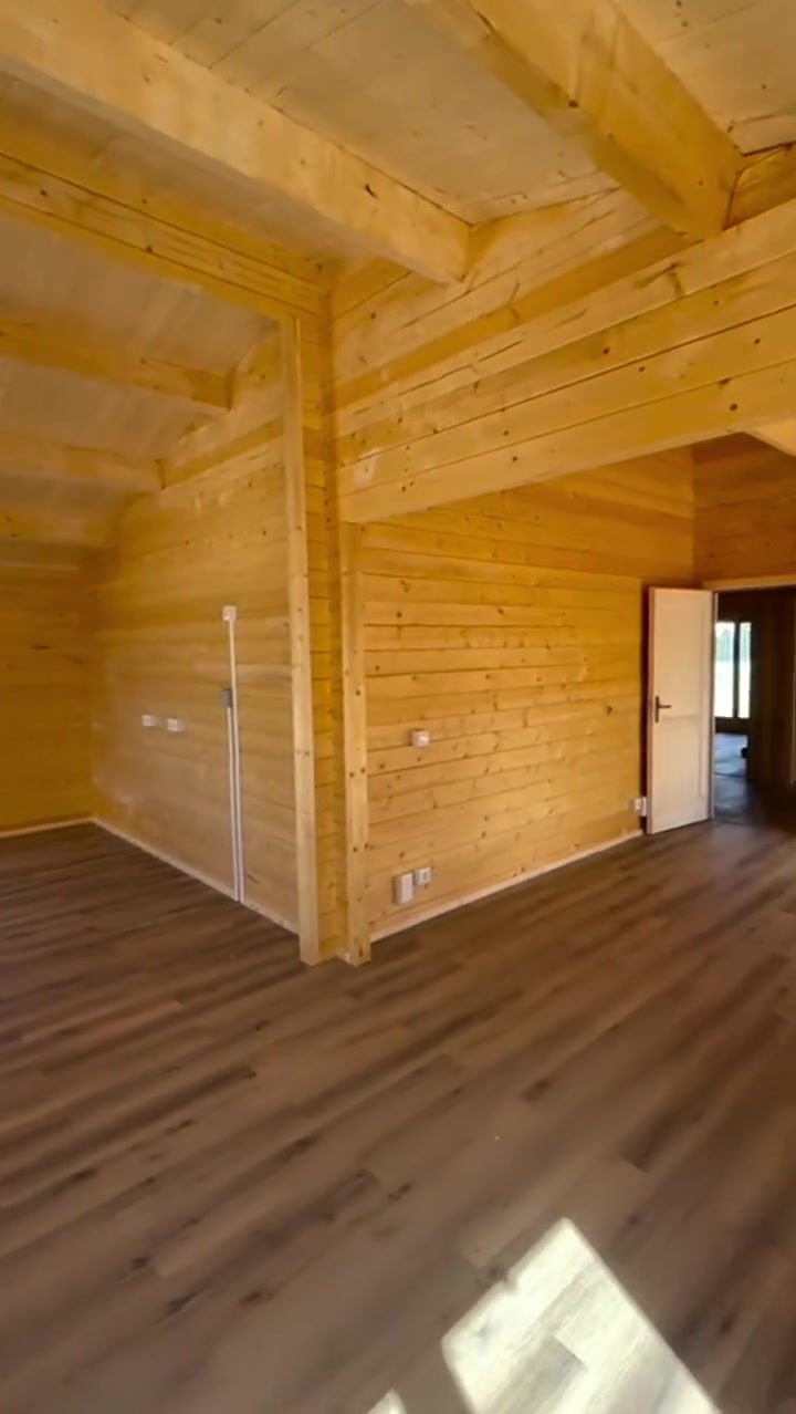 Sala com teto em pinho e vigas de madeira maciça, com acesso aos quartos