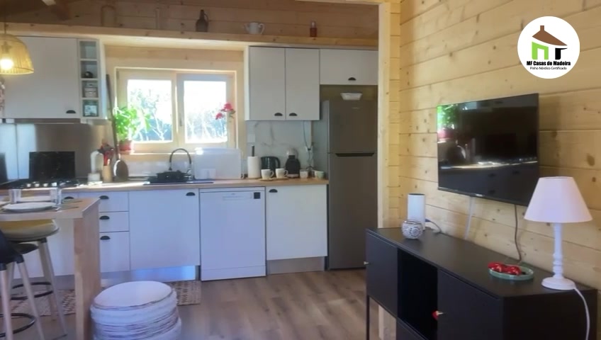 Sala e cozinha com paredes em pinho nórdico maciço à vista