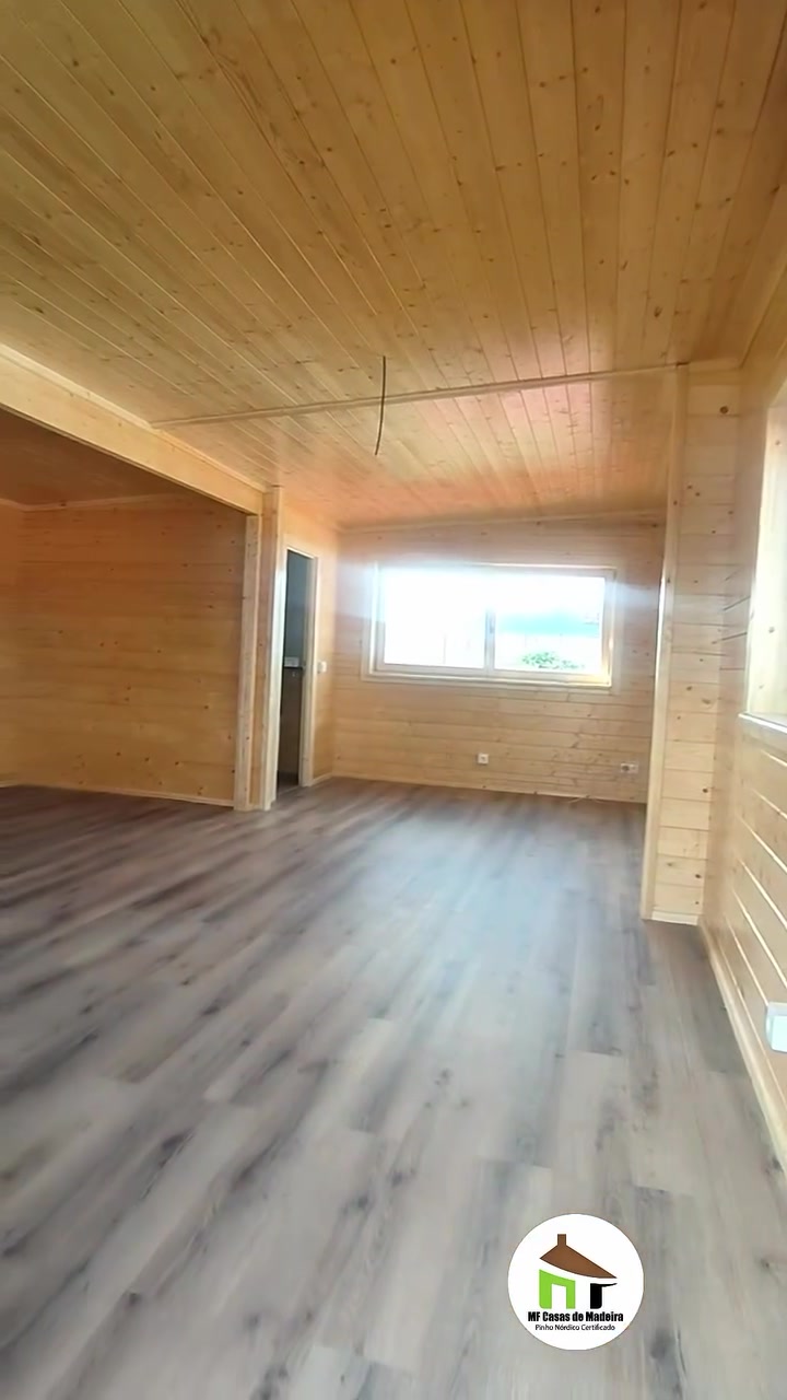Interior em open space da casa de madeira T0, com paredes e teto em pinho maciço