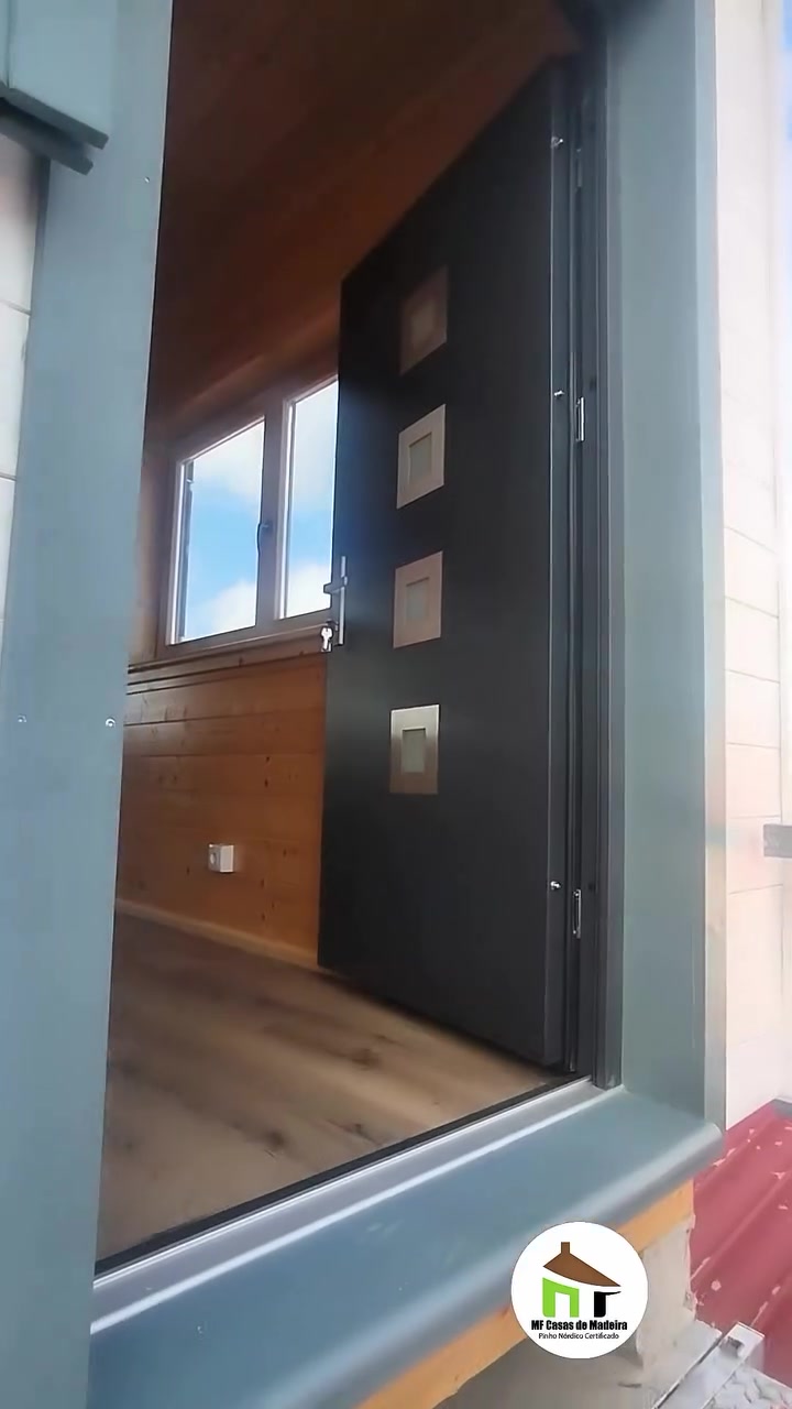 Porta de entrada da casa de madeira T0 com o interior em pinho à vista