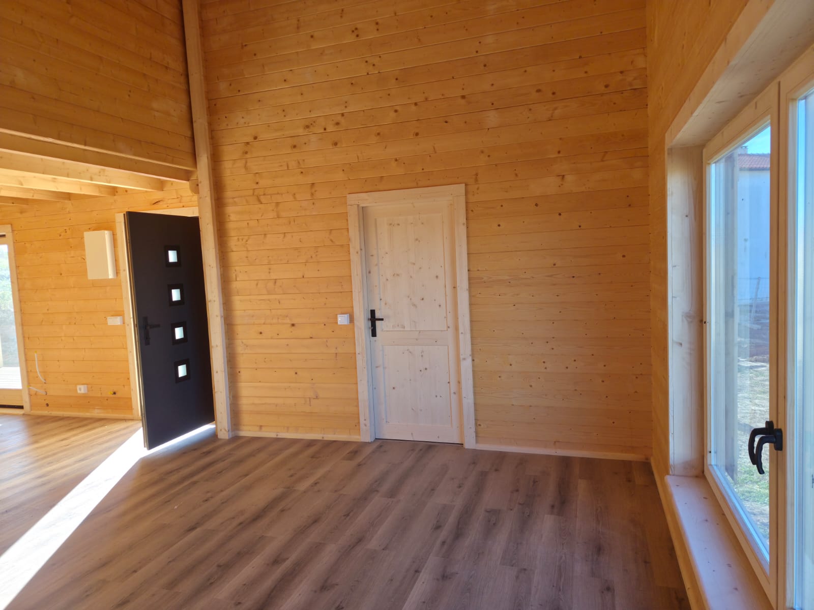 Hall com pé-direito duplo, porta interior em pinho maciço e janela