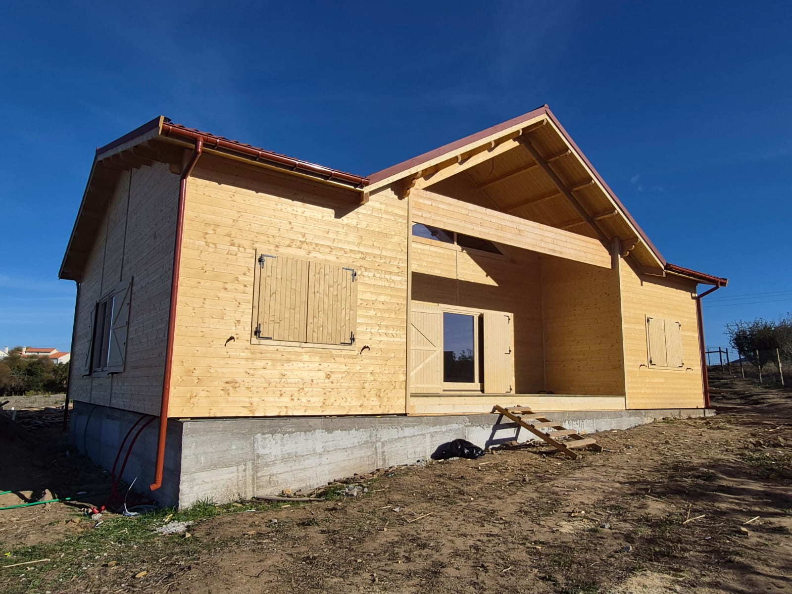 Casa de madeira maciça modelo Villa com mezanino, alpendre central e cobertura em telha, obra MF