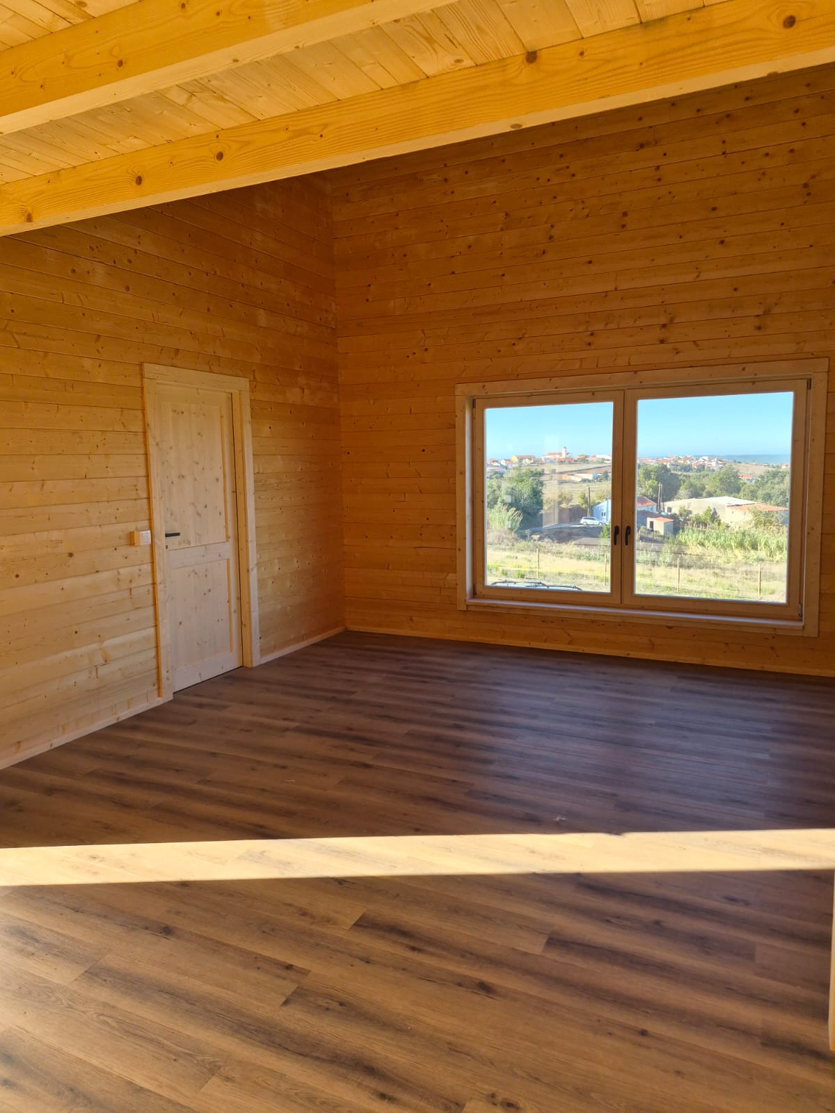 Quarto em madeira maciça com janela de batente e vista desafogada