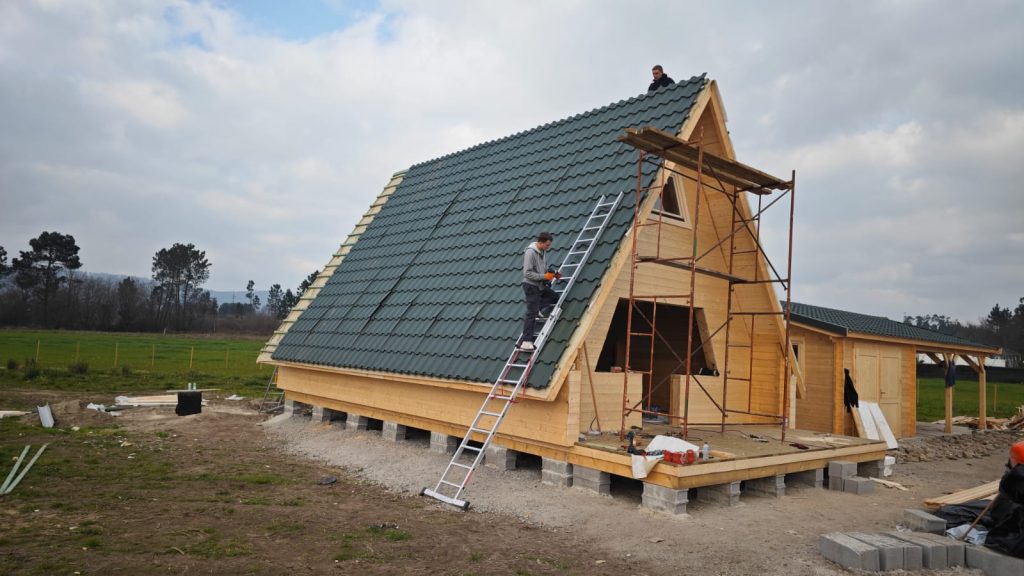 Revestimento da cobertura de uma casa A-Frame em chapa metálica verde com aspeto de telha