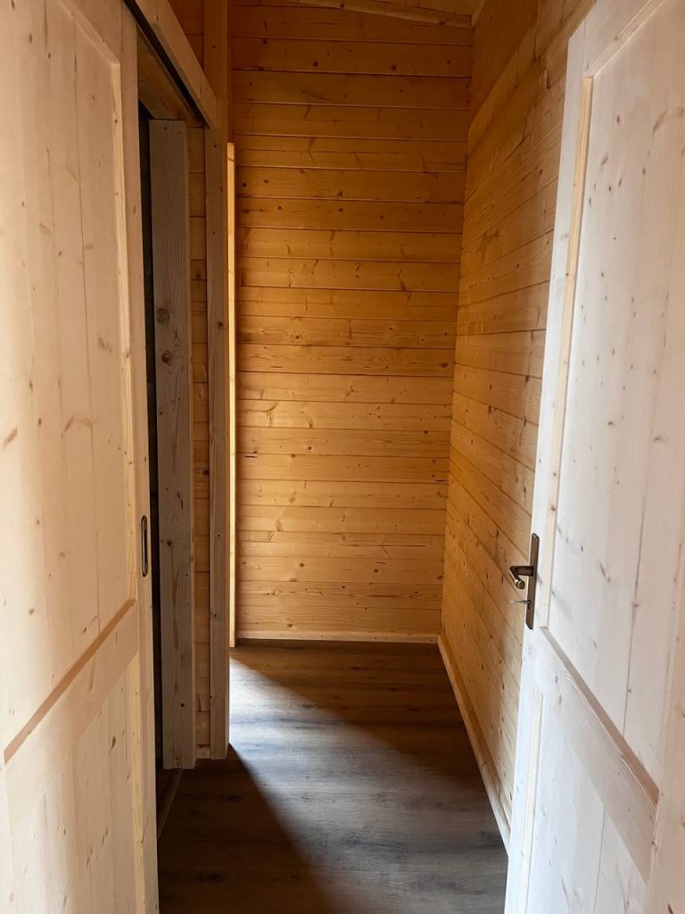 Corredor de casa de madeira com portas interiores em pinho maciço almofadadas