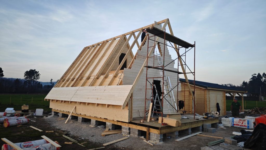 Empena em toros maciços empilhados em degrau e asnas em A numa casa A-Frame em construção