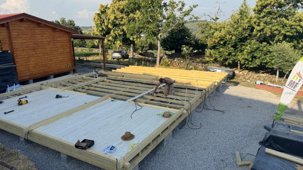 Estrutura do pavimento de uma casa de madeira com barrotes, tubagens e cabos elétricos