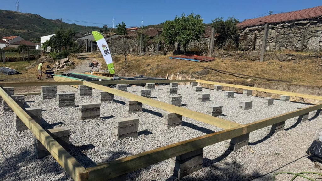 Fundações de casa de madeira em pilares sobre brita com vigas de perímetro em madeira tratada