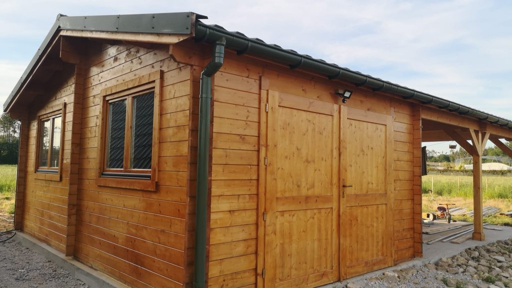 Garagem em madeira maciça com portão de duas folhas, cobertura verde e telheiro lateral
