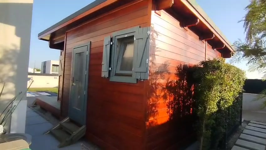 Anexo em madeira no quintal com porta de entrada lateral e janela com portadas