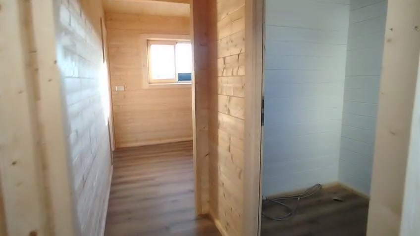 Interior do quarto extra com paredes em pinho nórdico maciço à vista e janela