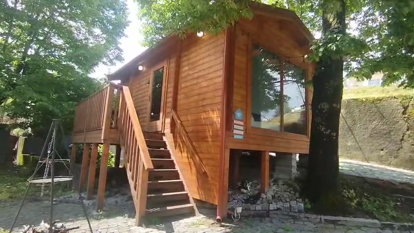 Tiny house na árvore com janela panorâmica e cobertura de duas águas